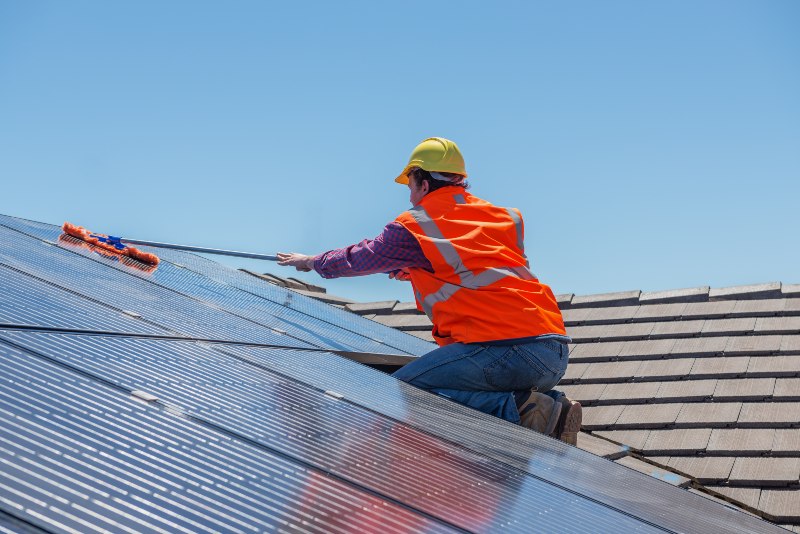 Solar panels installed by Kapital Electric, Inc., are being cleaned by a worker in Chicago, IL

