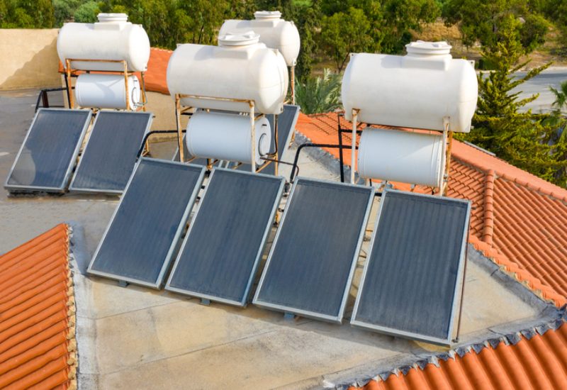 Eco-friendly solar water heater setup, with rooftop collectors and storage tanks in Chicago, IL