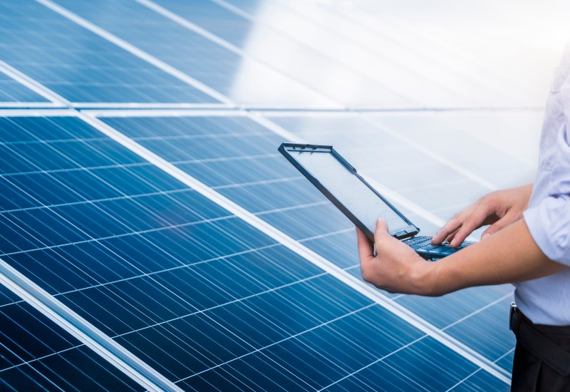 A technician conducting a solar audit for solar panels with a laptop in Chicago, IL